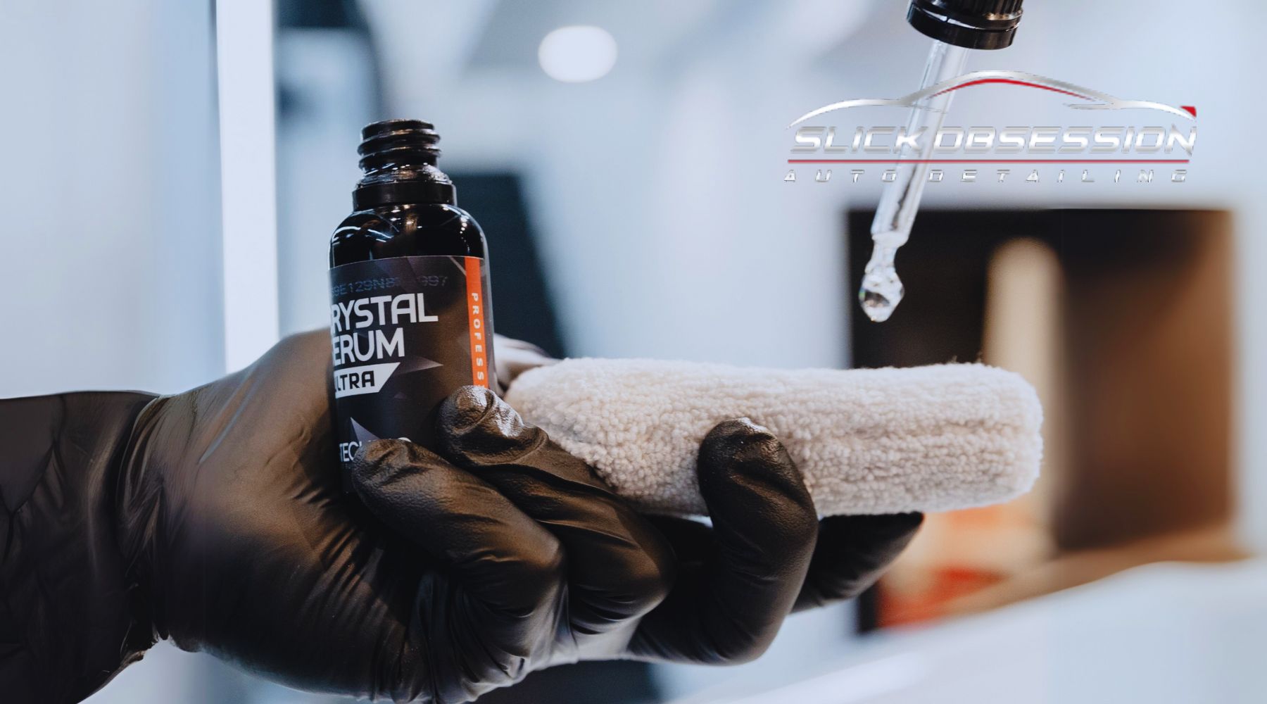 A gloved hand holds a small bottle labeled “Crystal Serum Ultra” while a dropper dispenses liquid onto a soft microfiber applicator, with the logo “Slick Obsession Auto Detailing” visible in the background.