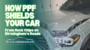 Front view of a light gray SUV having Paint Protection Film (PPF) professionally applied to the hood and headlights, with water droplets visible on the surface. Bold green and white text on the left reads, "How PPF Shields Your Car From Rock Chips on Birmingham's Roads" above the Slick Obsession Auto Detailing logo.