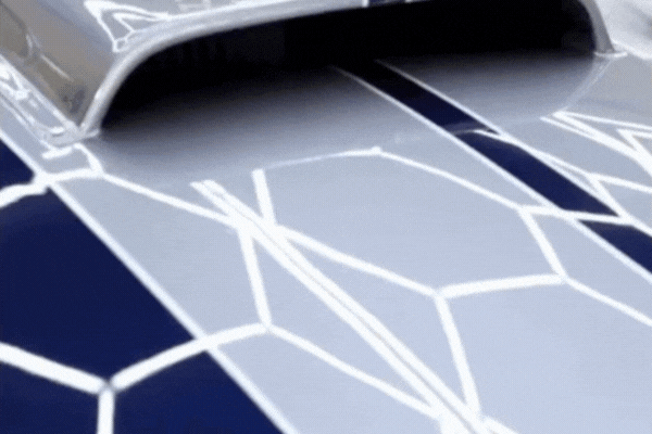 Close-up GIF of water beading and sliding off a blue and silver ceramic-coated hood as a demonstration of hydrophobic performance, captured during application at Slick Obsession Auto Detailing in Birmingham, AL. This visual reinforces the benefits behind the question: What Is Ceramic Coating.