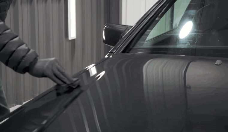 Interior view from the driver’s seat showing intense sunlight shining through the windshield onto the dashboard while driving on a bright Birmingham summer day. The image illustrates how solar heat and glare build up inside a vehicle without high performance window tint protection.